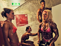 Bodybuilders pump up their muscles backstage before performing in Budapest, May 10