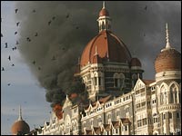 In this Nov. 27, 2008 file photo, pigeons fly as the Taj Hotel burns during the terror attacks in Mumbai