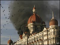In this November 27, 2008 file photo, pigeons fly as the Taj Hotel burns during the terror attacks in Mumbai